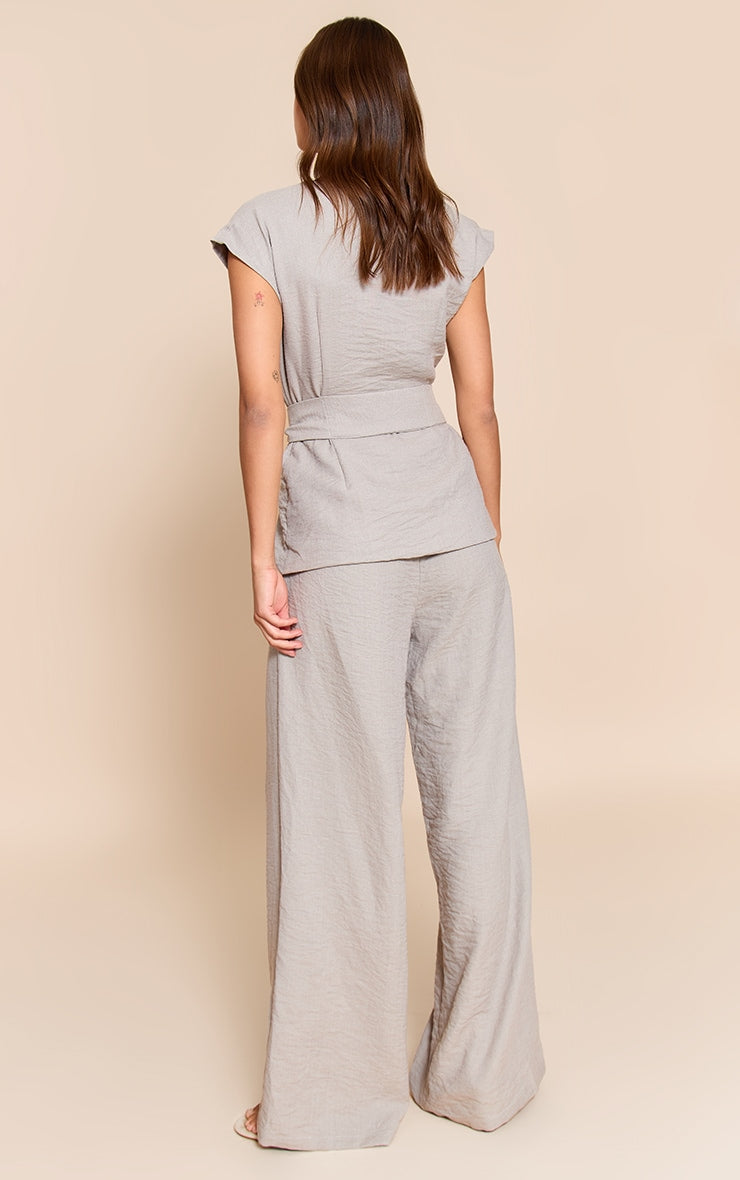https://cdn-img.prettylittlething.com/8/4/f/7/84f7ef863a8a4ac11e18cde8623b3596df62d422_CNN7785_2_taupe_textured_tie_waist_jumpsuit.jpg