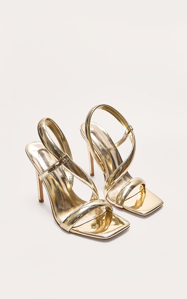 https://cdn-img.prettylittlething.com/d/2/d/b/d2db20087d9e94e001e411d351f731445472563e_CNJ5048_2_gold_metallic_pu_square_toe_padded_asymmetric_high_heeled_sandals.jpg